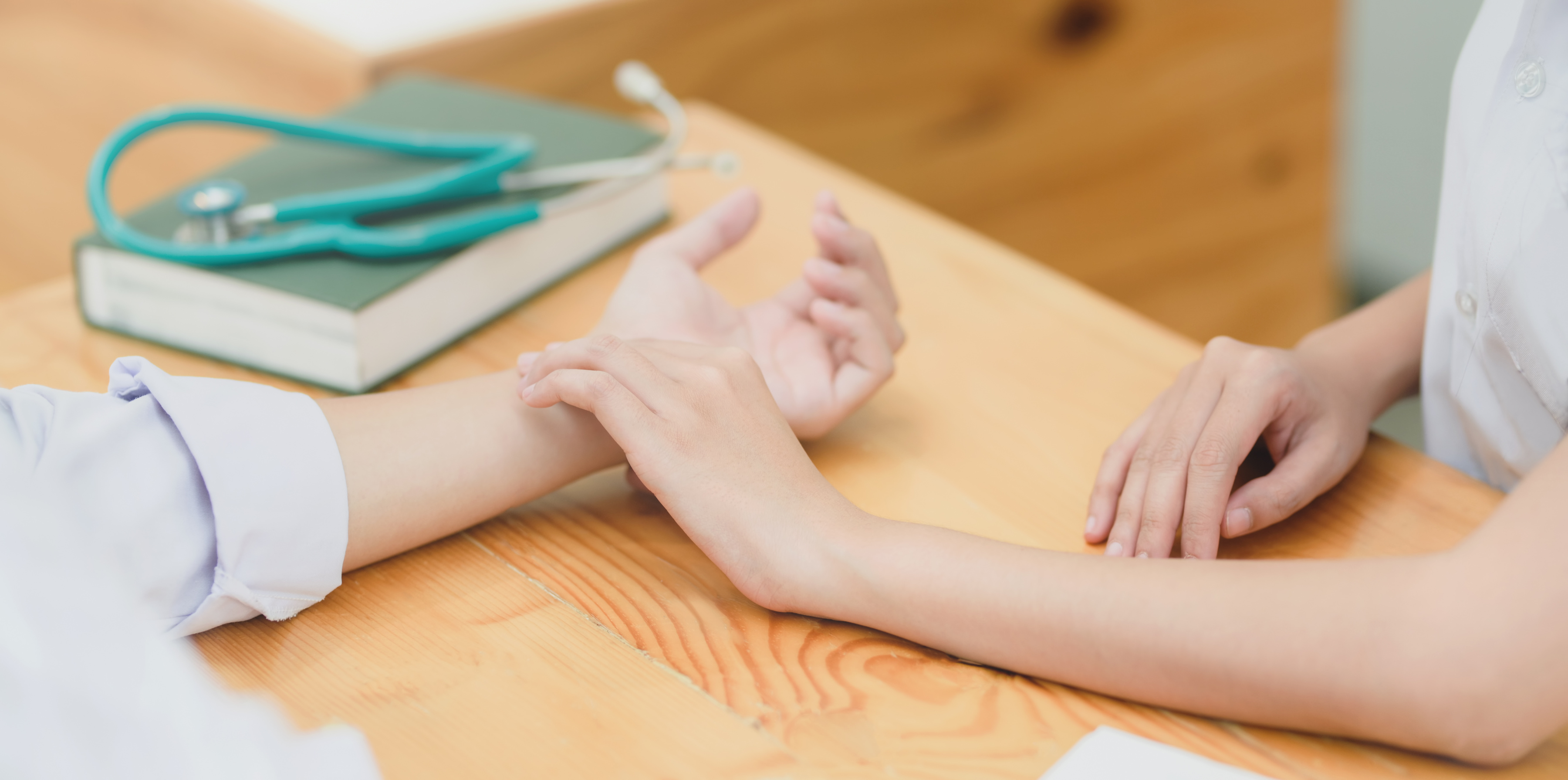 Crop nurse checking pulse on patients wrist